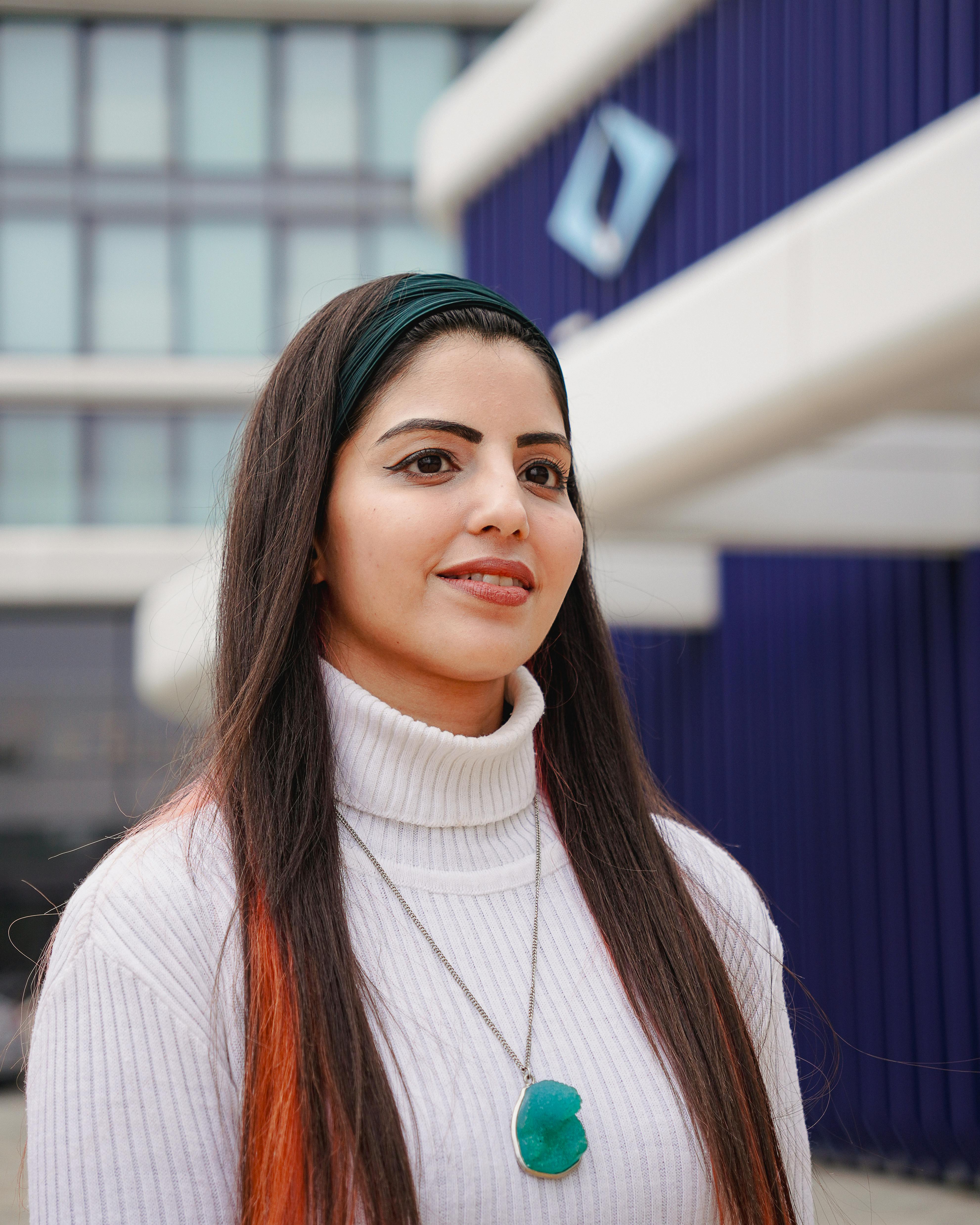 Portrait of a young woman with long hair, wearing a turtleneck, outdoors in Istanbul.