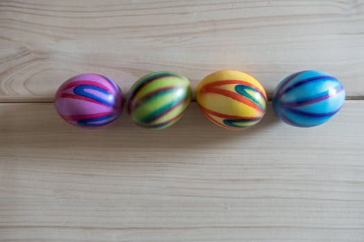 Vibrant and colorful swirled Easter eggs lined up on a wooden surface, symbolizing Easter joy.