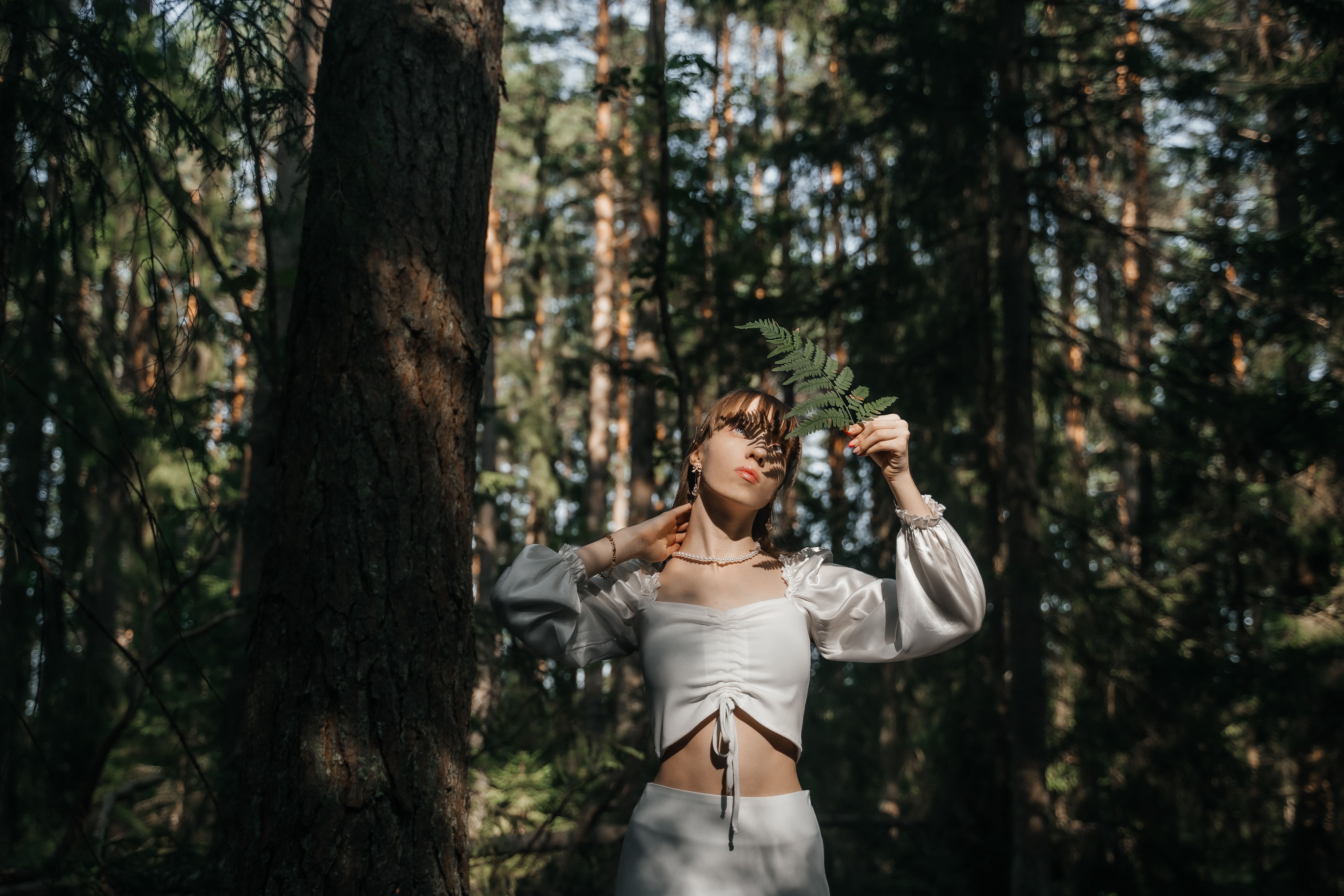 Young Woman Posing with Fern Leaf in Forest · Free Stock Photo