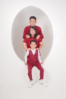 A cheerful family portrait with red attire in a studio environment.