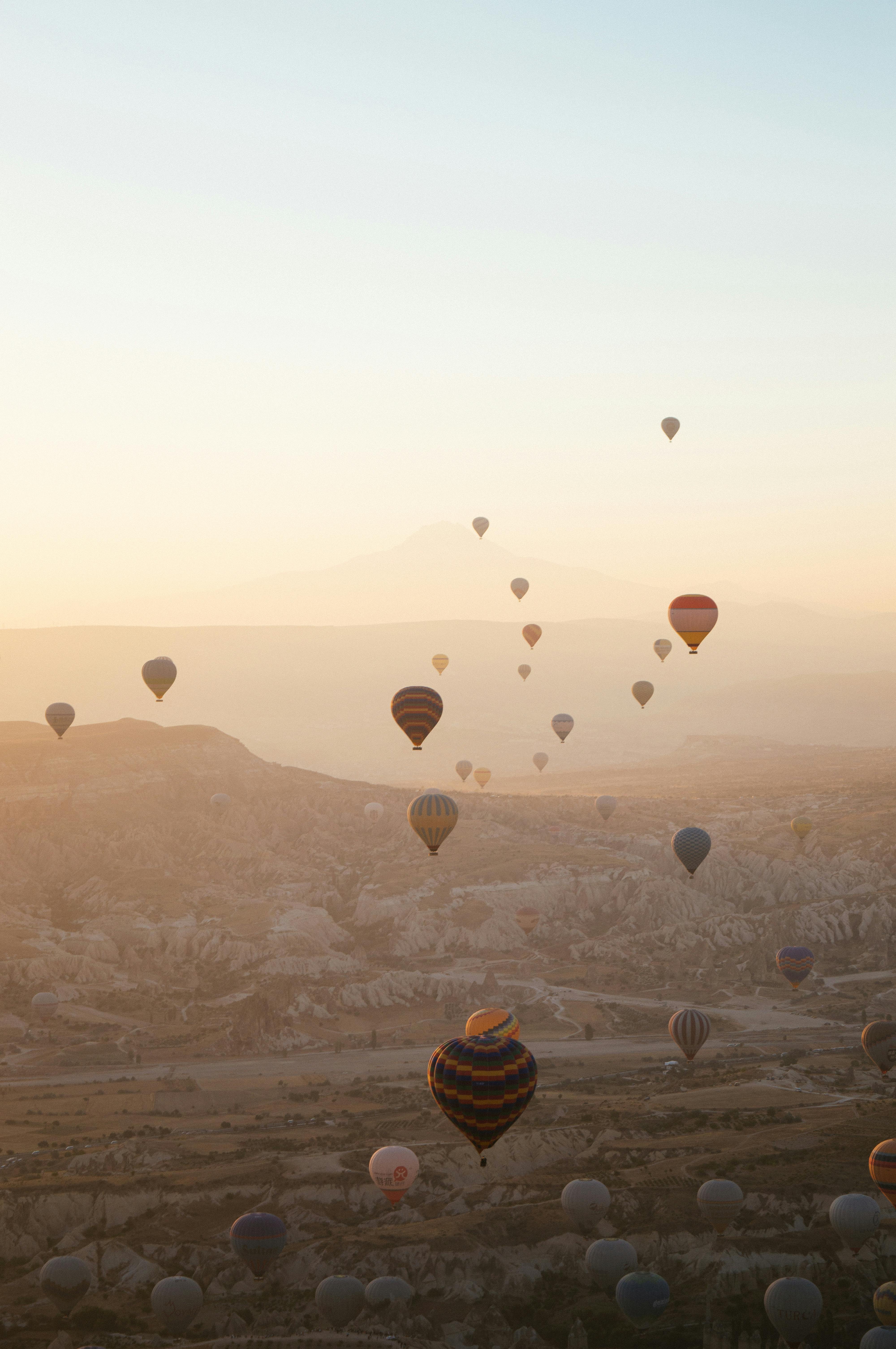Hot air balloons floating over Cappadocia at sunrise, creating a stunning scenic view.