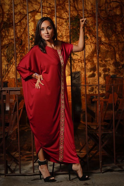 Free Fashionable woman in a red gown posing stylishly against a wrought iron fence. Night setting in Puebla. Stock Photo