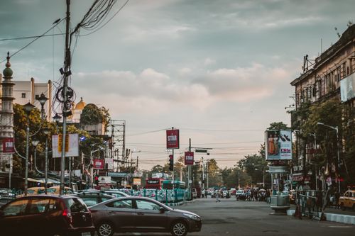 Free Vibrant street view of Kolkata showcasing city life, architecture, and traffic at dusk. Stock Photo