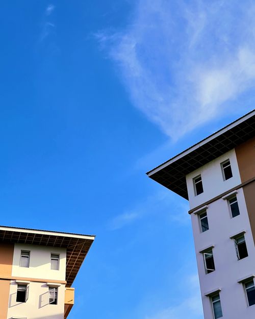 Free Sunny view of modern building rooftops and windows under a clear blue sky. Stock Photo