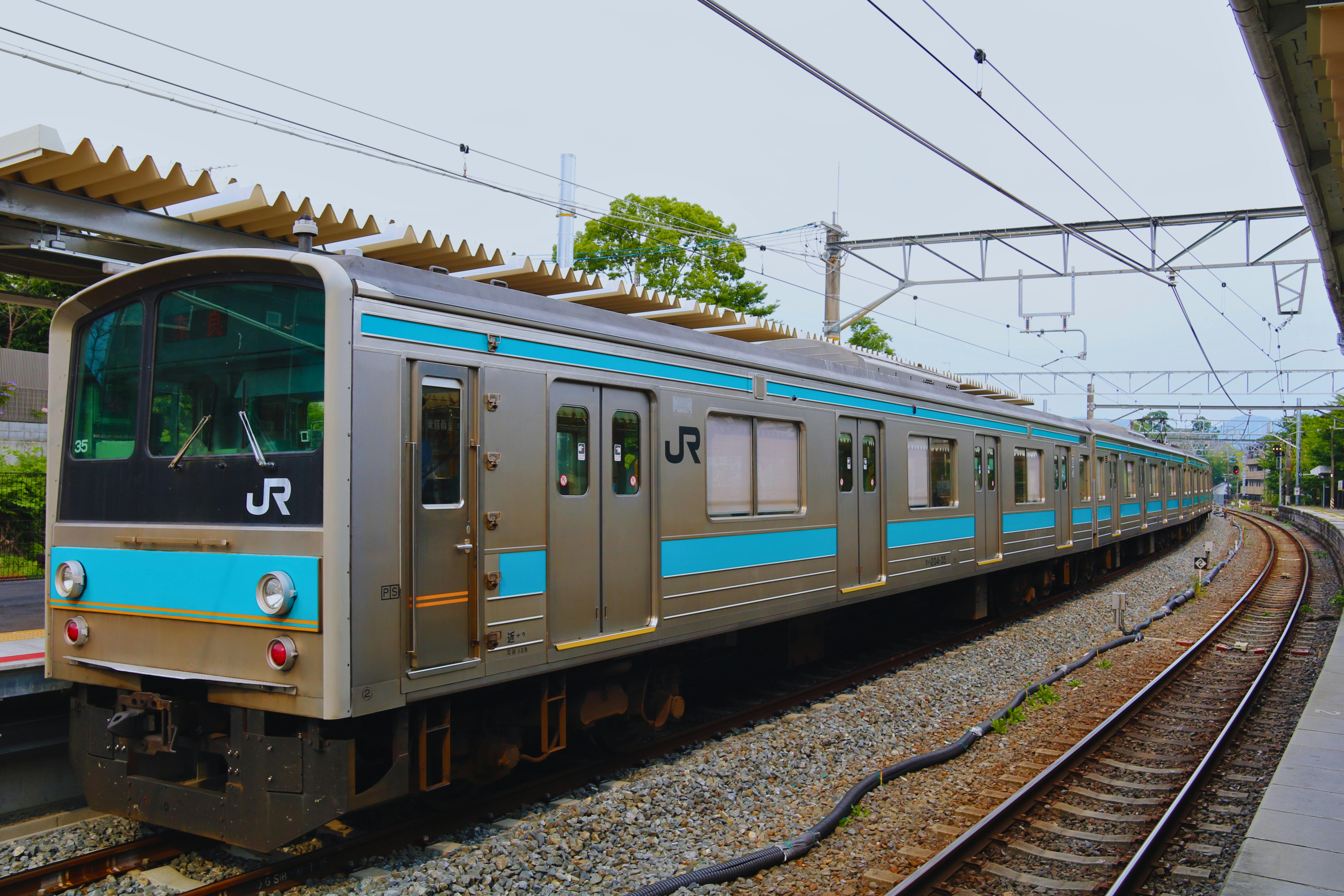 A JR train at a serene Kyoto station, showcasing Japanese transit and architecture.