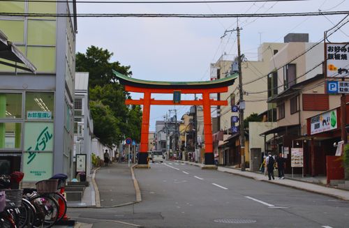 Free A traditional Torii gate stands prominently on a busy street in Kyoto, Japan. Stock Photo