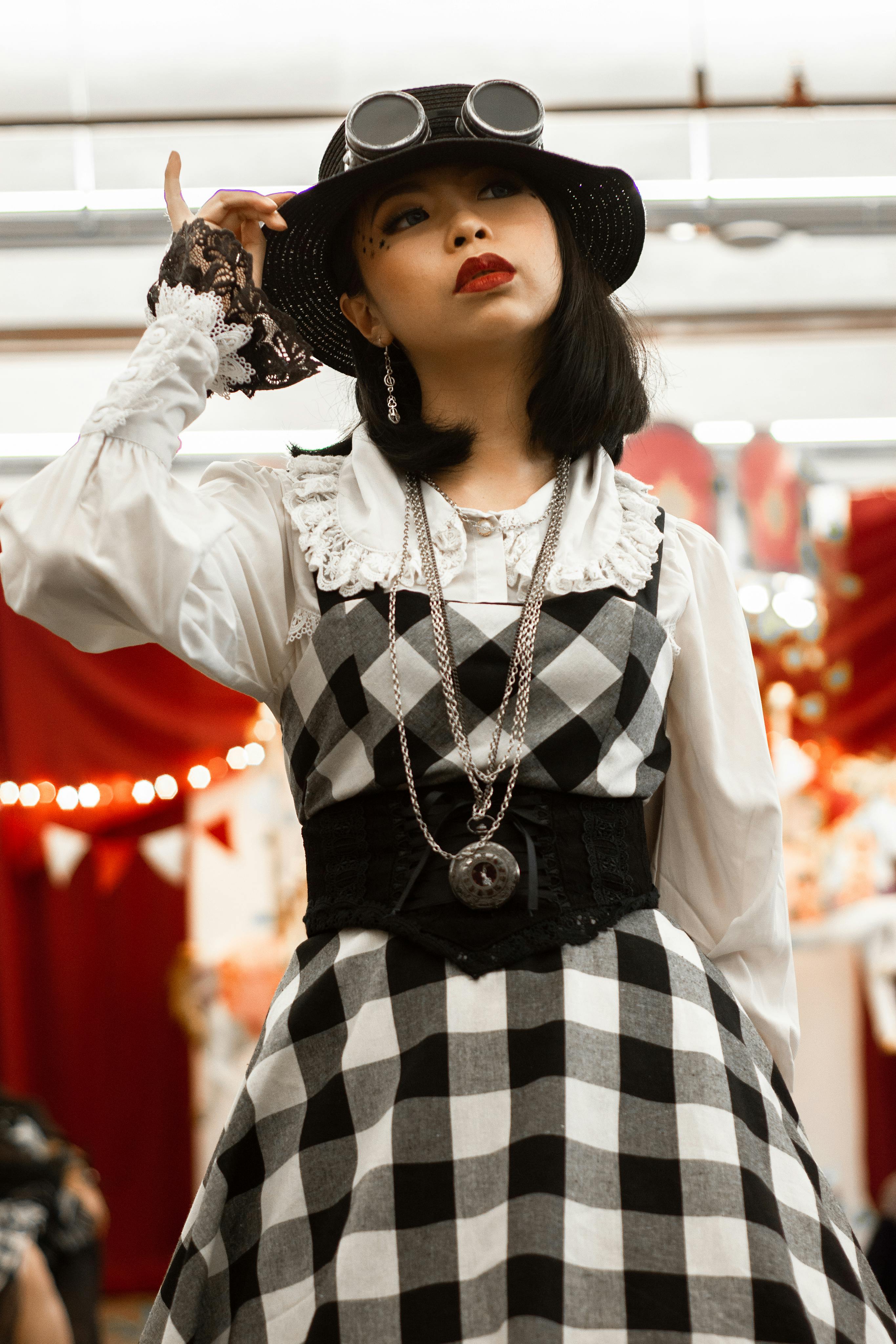 Portrait of a woman in steampunk attire with checkered dress, indoors.