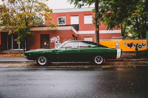 Free Green Coupe Parked on Gray Asphalt Road Stock Photo