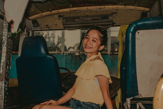 Cheerful teenager seated in a rustic van, showcasing a joyful smile.