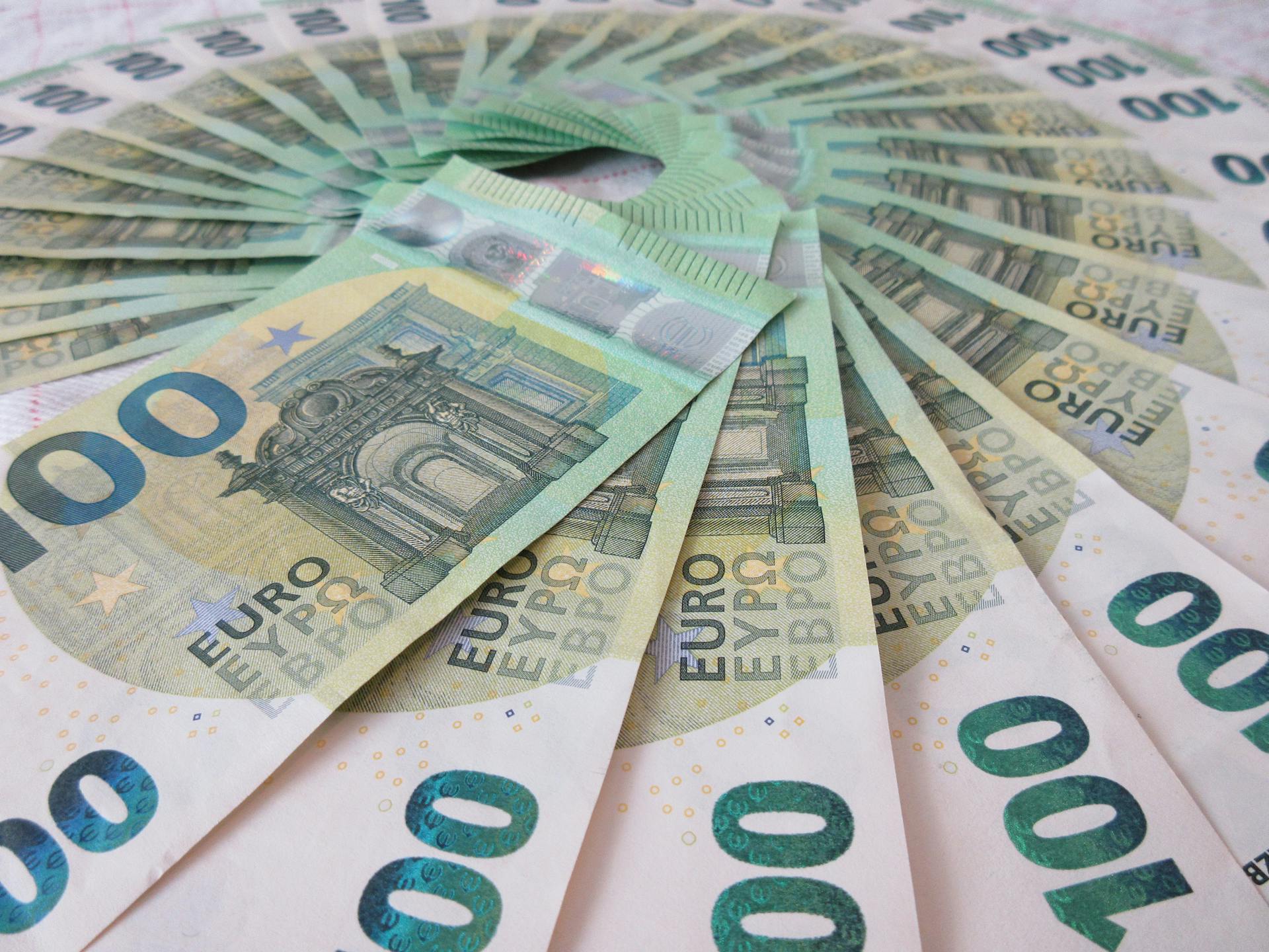 Close-up of fan spread 100 Euro banknotes, showcasing wealth and finance theme.