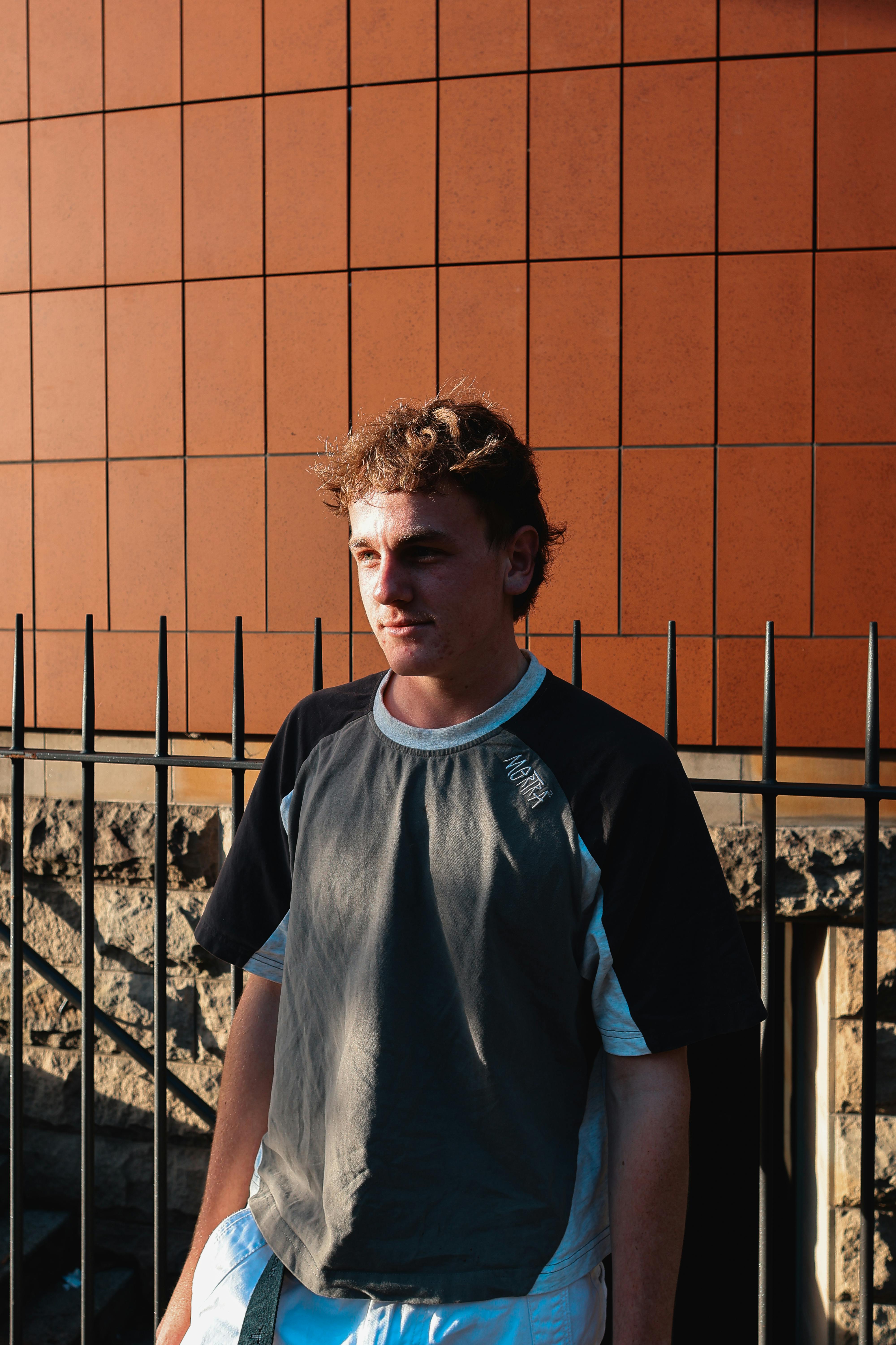 bezplatná Mladý muž pózuje v The Rocks, Sydney se slunečním světlem vrhajícím teplou záři. Základová fotografie