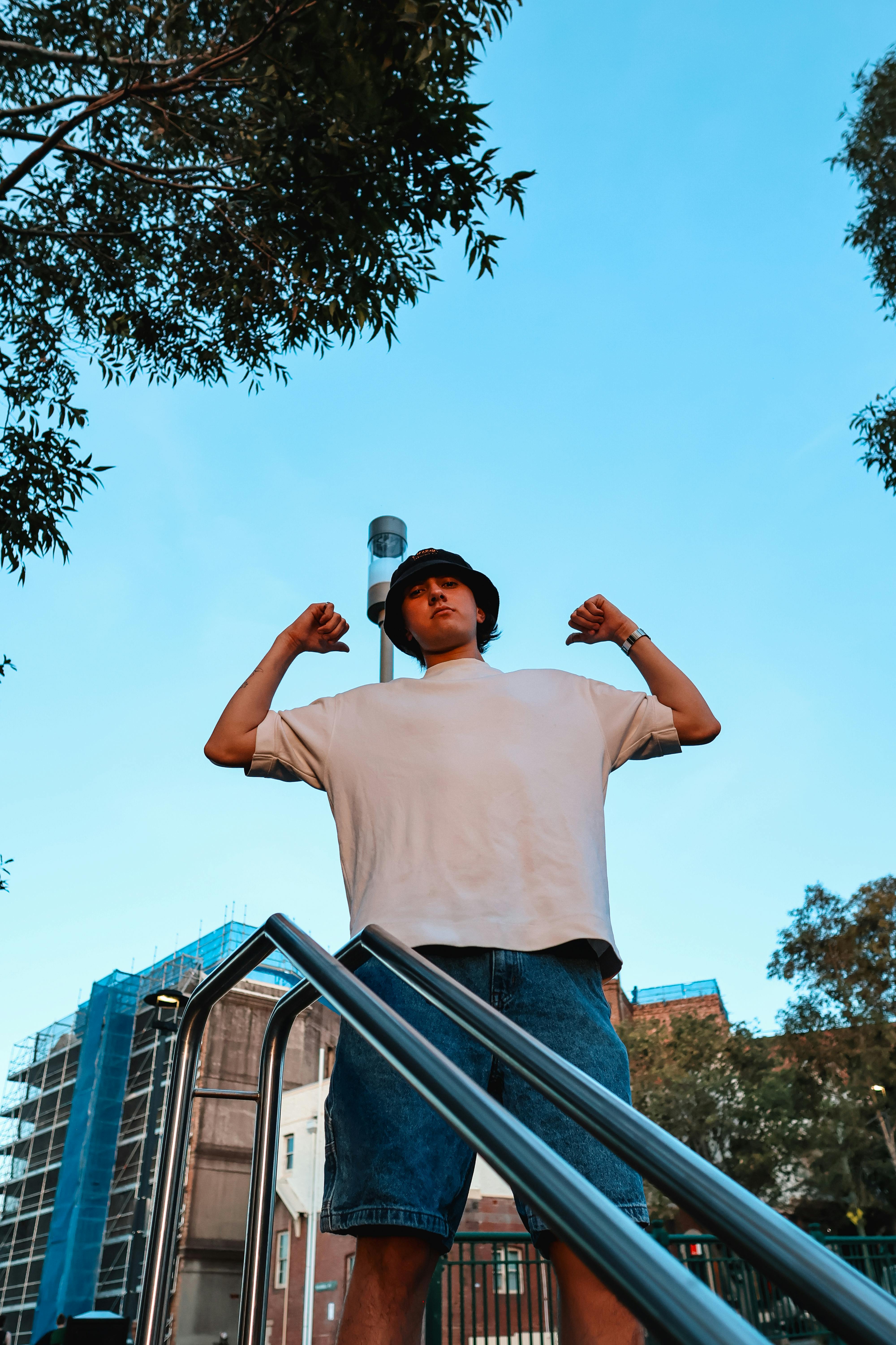 Gratis Potret dinamis seorang model fesyen berpose dengan percaya diri di luar ruangan di lanskap perkotaan Sydney. Foto Stok