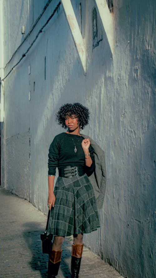 Free A fashionable woman posing in a Moroccan-style street, showcasing urban chic. Stock Photo