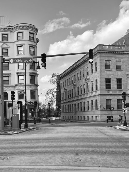 Free Black and white photo of a historic city street intersection with classic architecture and traffic lights. Stock Photo
