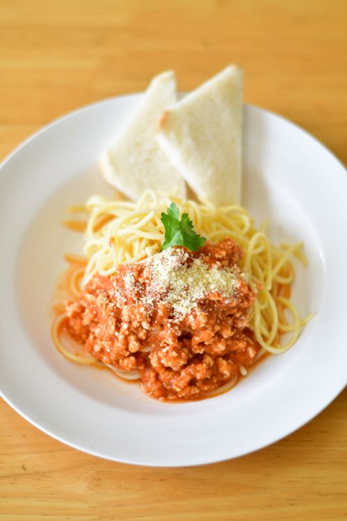 Free Plate of spaghetti bolognese garnished with parsley and served with toasted bread. Stock Photo