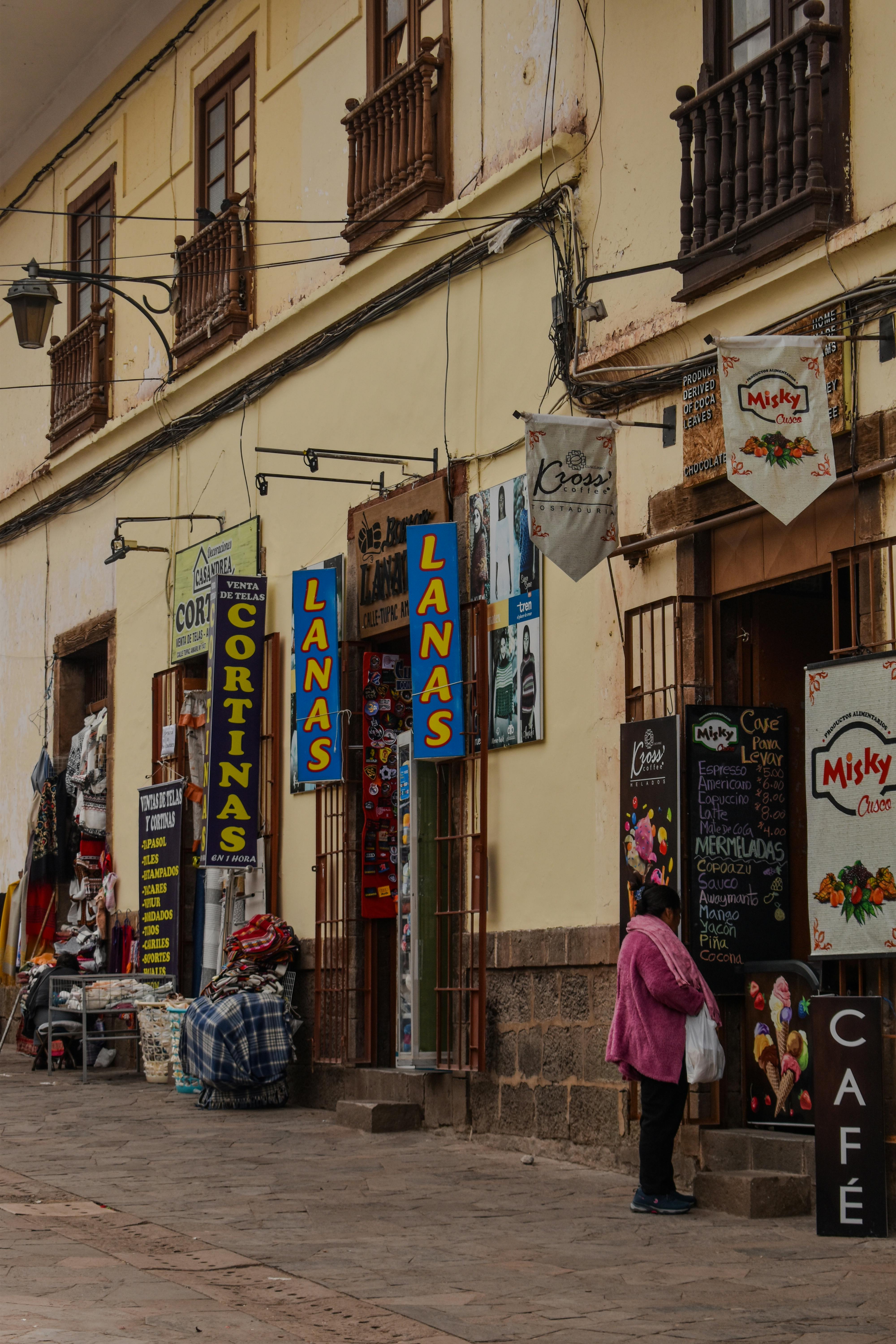 Street view of a bustling local market in Cusco, showcasing Peruvian culture and architecture.