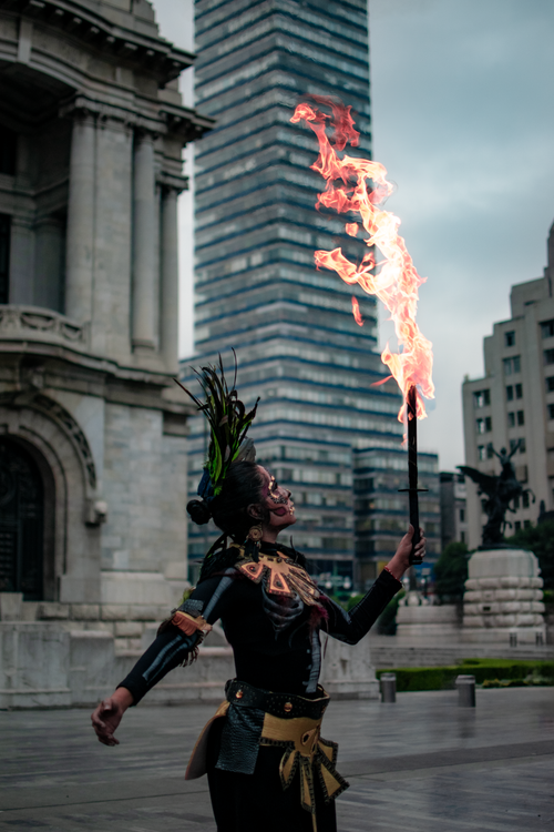 Free A captivating scene of a traditional performer with a fiery torch in a bustling cityscape. Stock Photo