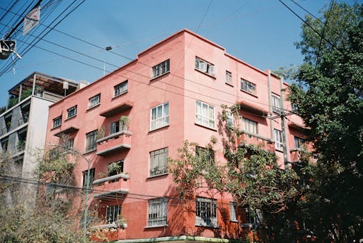 A colorful vintage apartment building in Mexico City on a bright sunny day.
