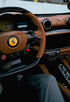 Experience the sleek design of a Ferrari with rich tan leather interior and modern controls.