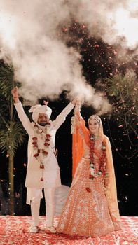 A happy couple celebrates an Indian wedding with vibrant attire and festive atmosphere.