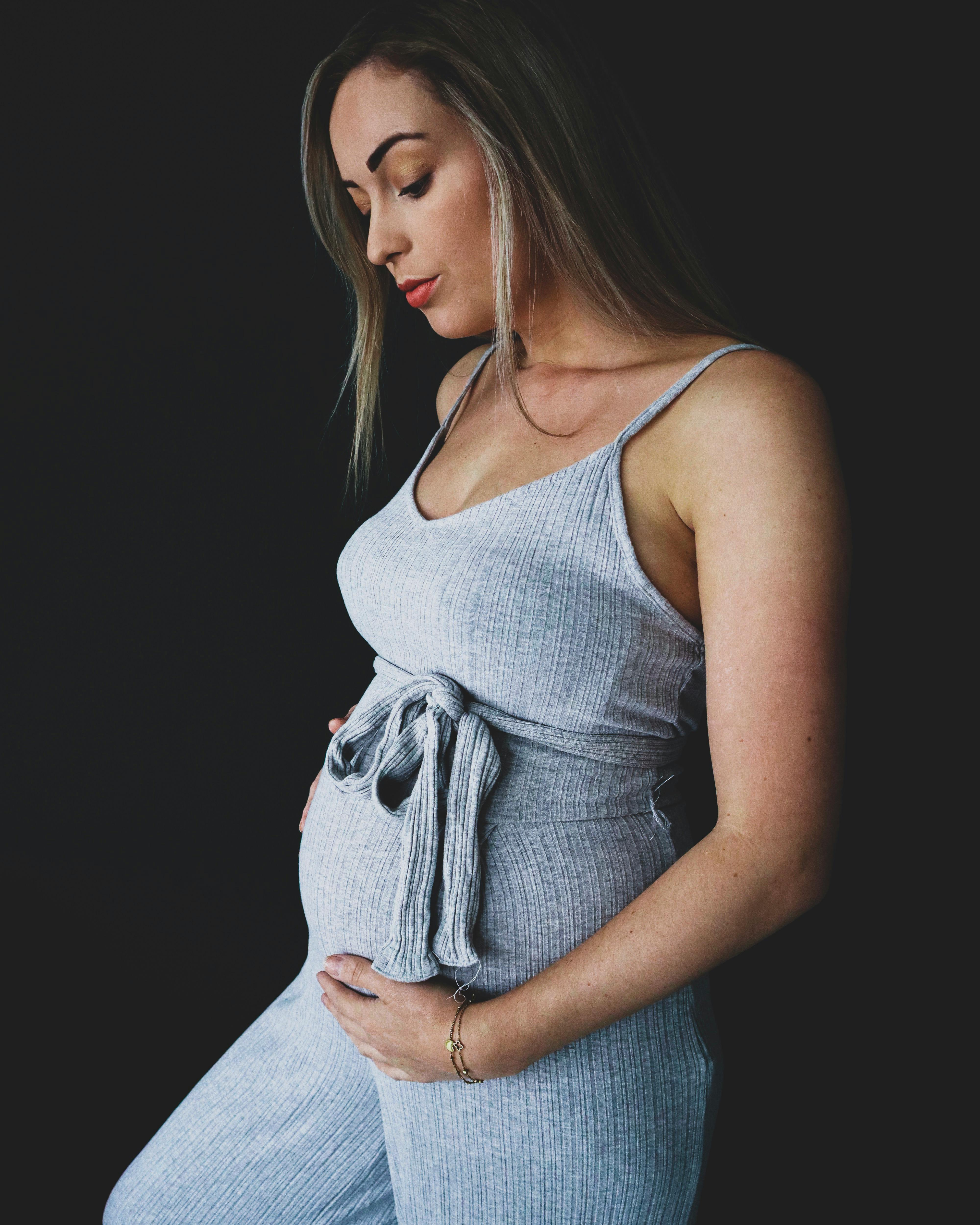 a pregnant woman wearing grey sleeveless romper