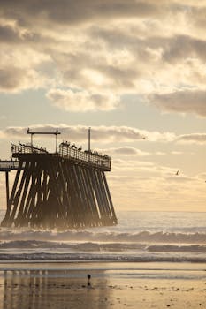 A serene sunset at Rosarito Beach with the pier silhouetted against the ocean waves.