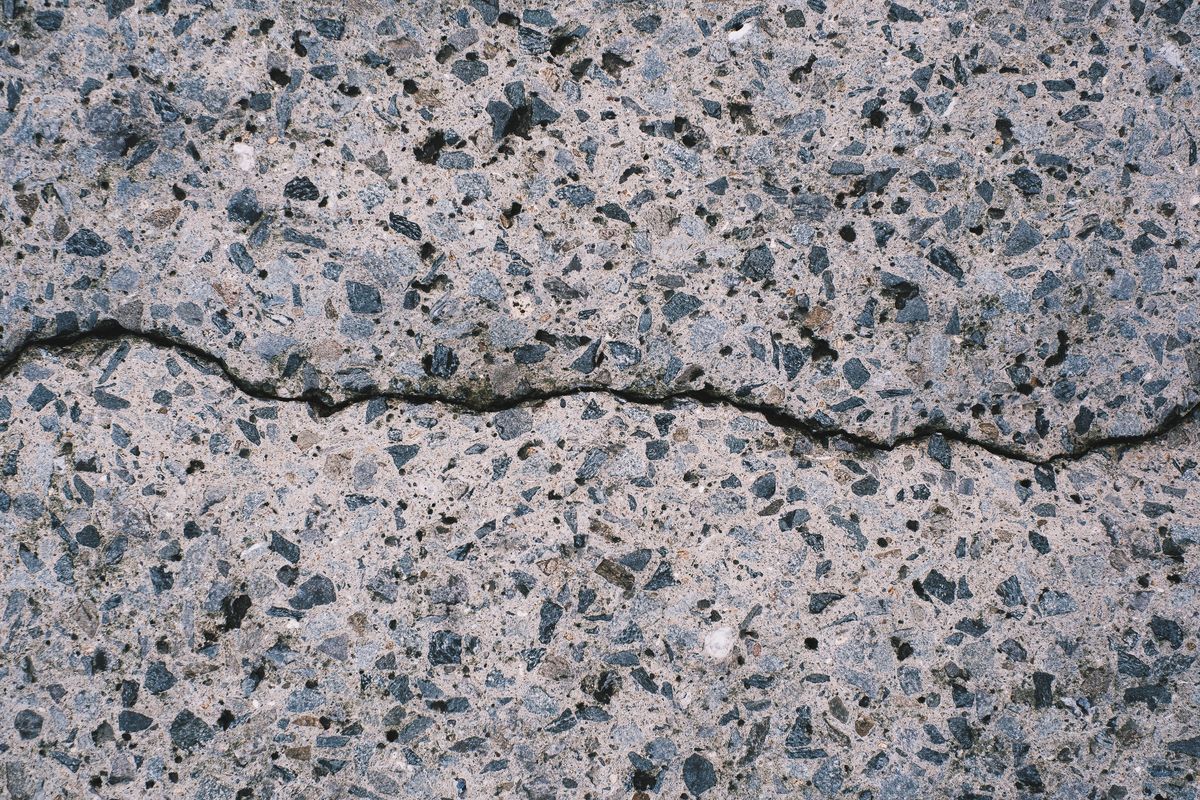 Crack running across a concrete driveway surface