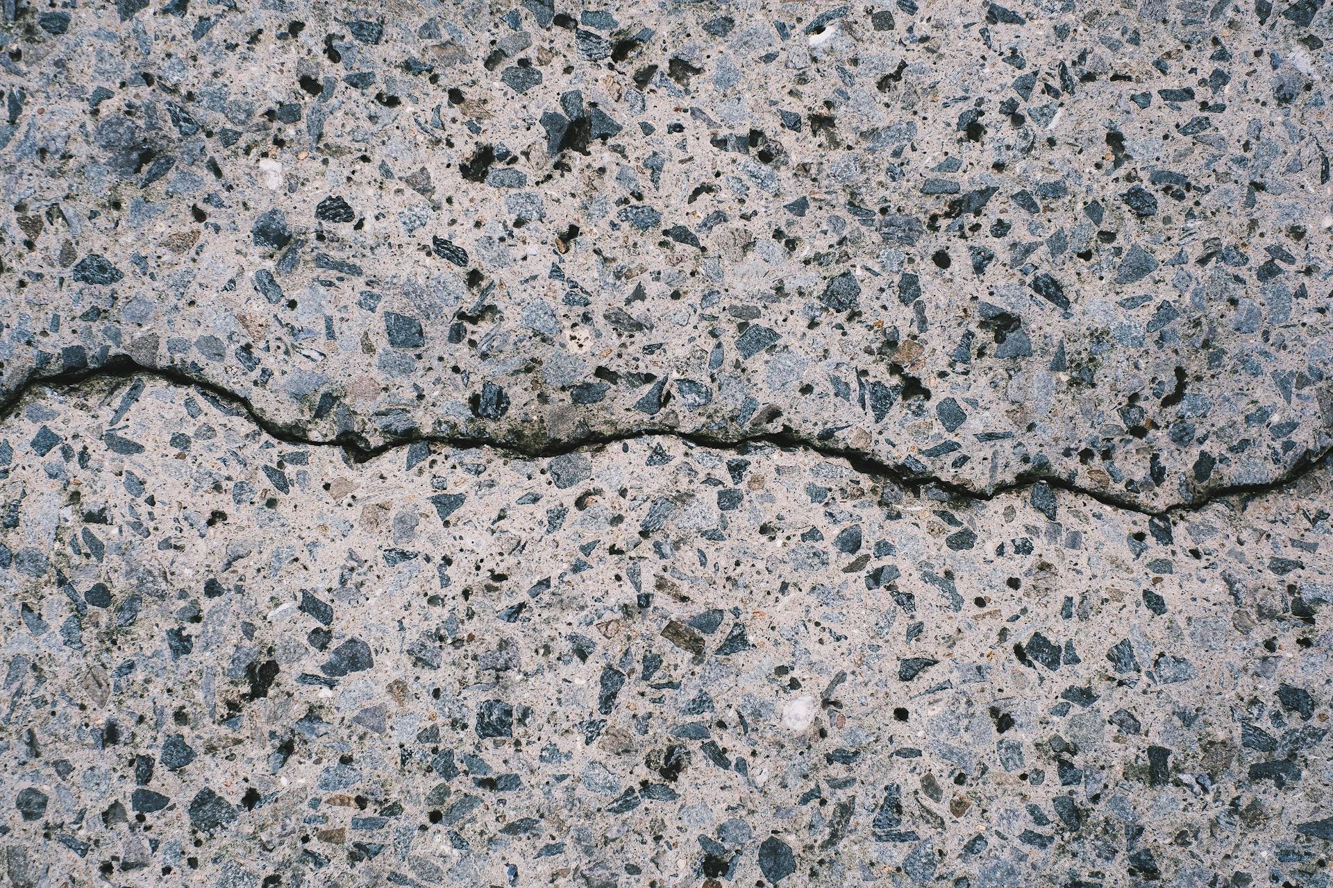 Detailed view of a textured concrete surface with visible aggregate and cracks.