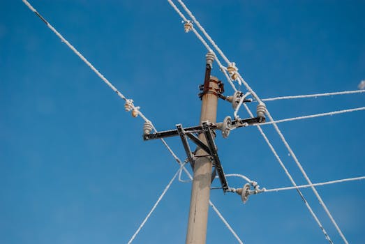 Frost-covered utility pole wires under a clear blue sky in Harbin, winter scene.