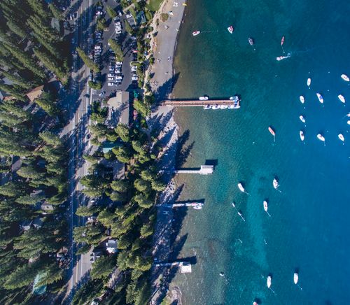 Free Aerial shot of Lake Tahoe with docks, beach, and boats visible from above. Stock Photo