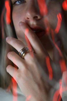Close-up portrait of a woman with rings, artistic bokeh lights.