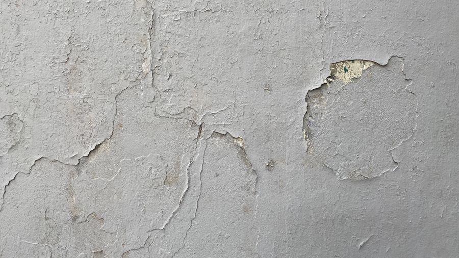 Cracked, peeling plaster wall before repainting in Cambridge