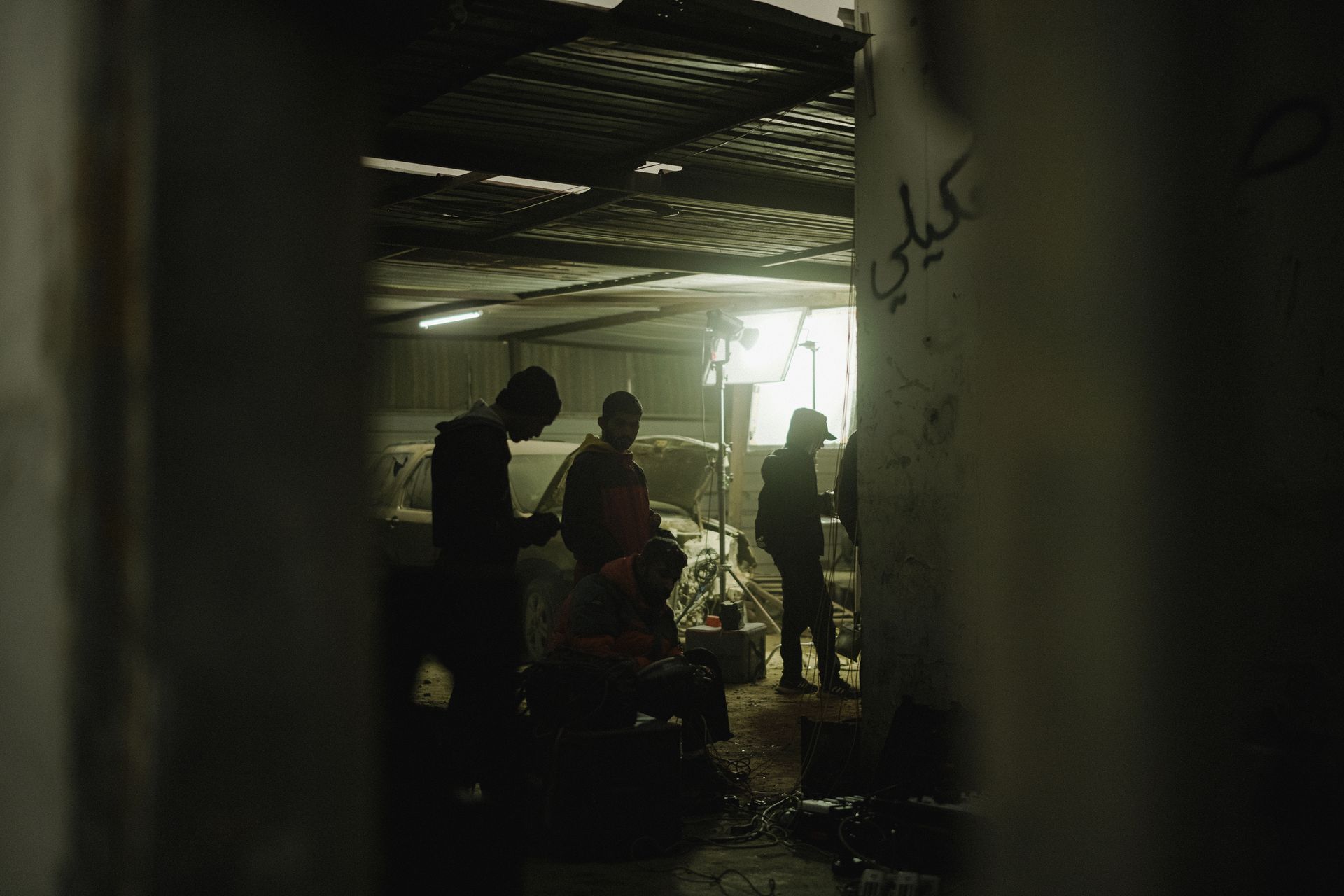 Silhouettes of people working in a dimly lit workshop, creating a moody atmosphere.