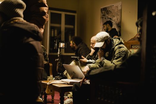 A group of people engaging in focused work in an intimate indoor setting.