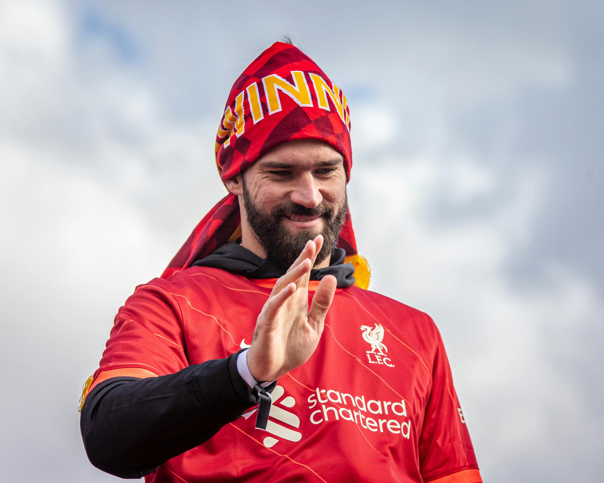 Liverpool FC player joyfully celebrates victory under the clear sky.
