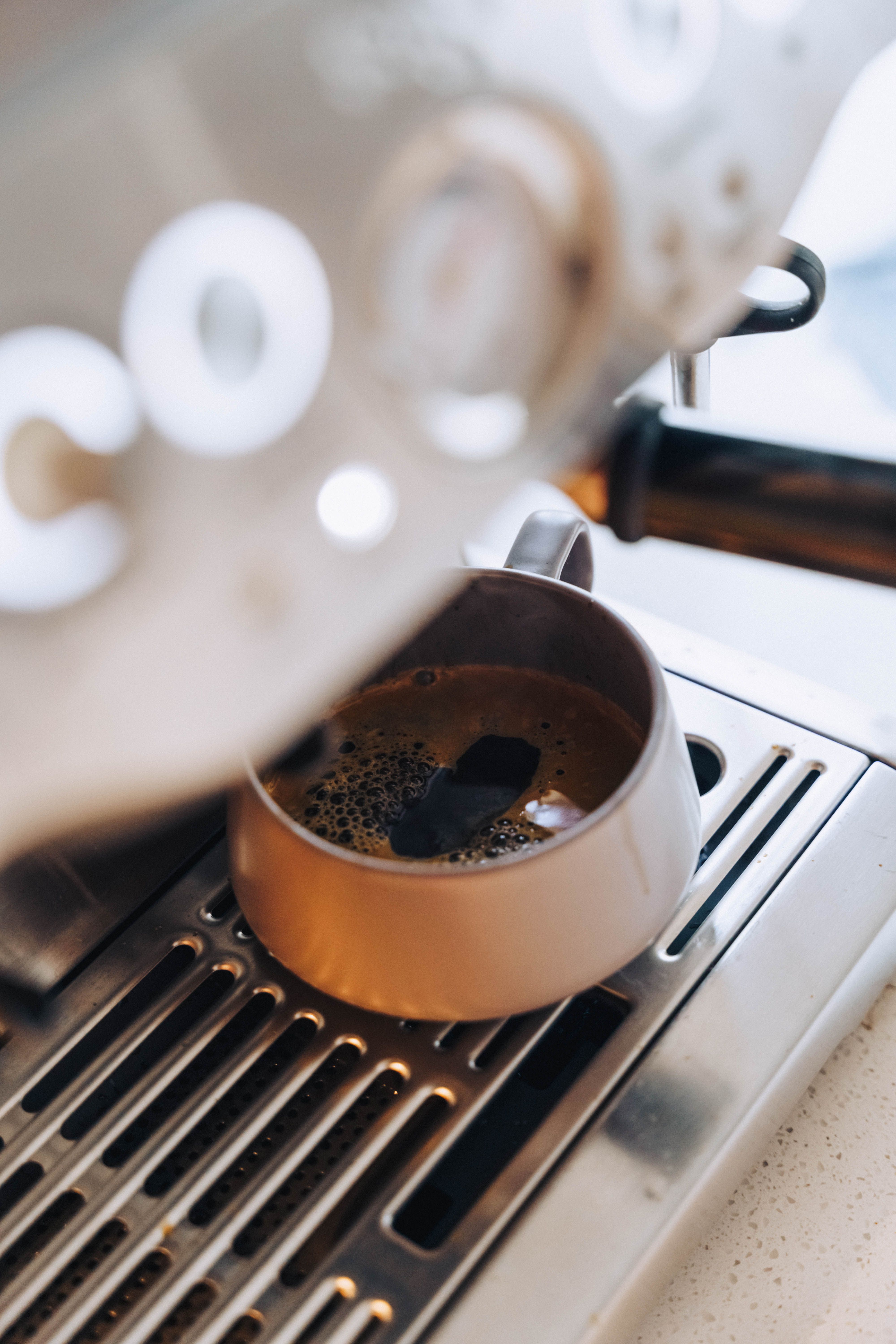 Fresh espresso brewing in a modern coffee machine, showing rich crema.