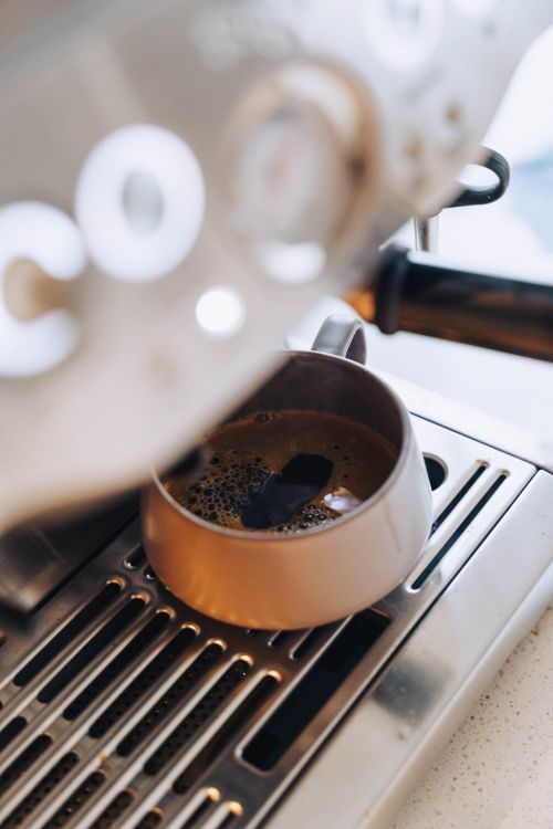 Fresh espresso brewing in a modern coffee machine, showing rich crema.