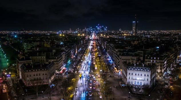 Vivid aerial view of Paris at night, showcasing bustling streets and city lights.
