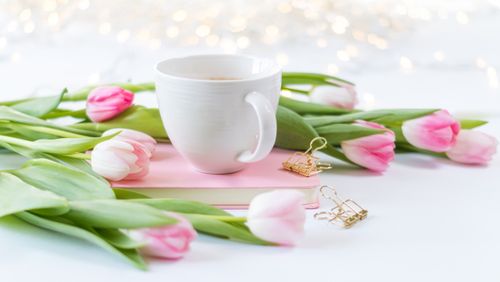 Free A serene springtime arrangement of tulips and coffee on a white background. Stock Photo