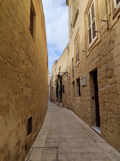 Free Charming narrow street with limestone walls in the historical city of Mdina, Malta. Stock Photo