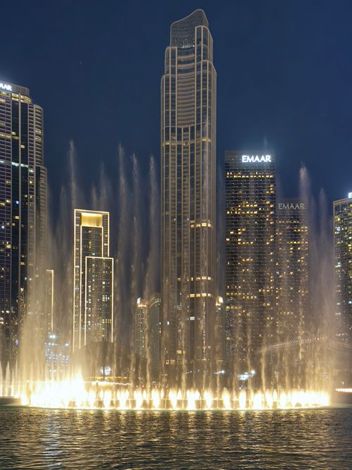 Free Stunning night view of the Dubai Fountain and illuminated skyscrapers, capturing the vibrant city. Stock Photo