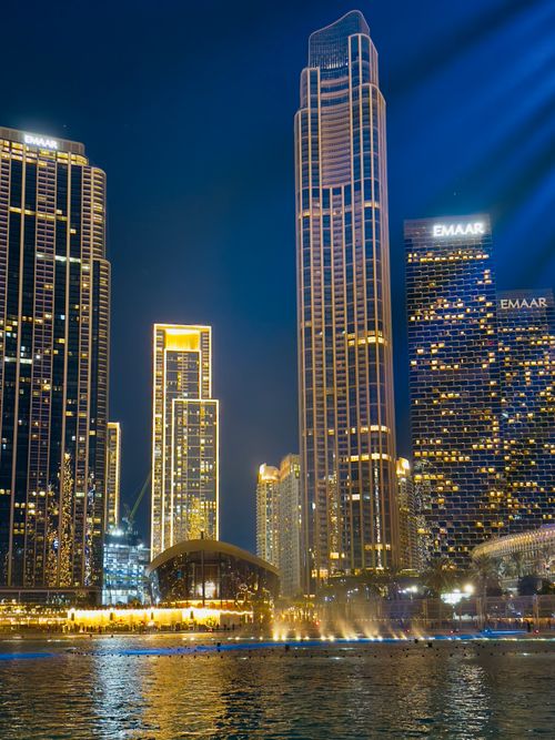Free Stunning night view of illuminated skyscrapers reflecting on Dubai's waterfront. Stock Photo