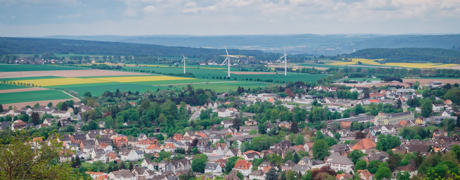 A scenic aerial view of Stadtoldendorf, Lower Saxony, Germany with fields and wind turbines.