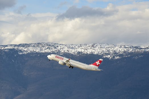 A Swiss airplane taking off with snow-capped mountains in the background in Geneva, Switzerland.
