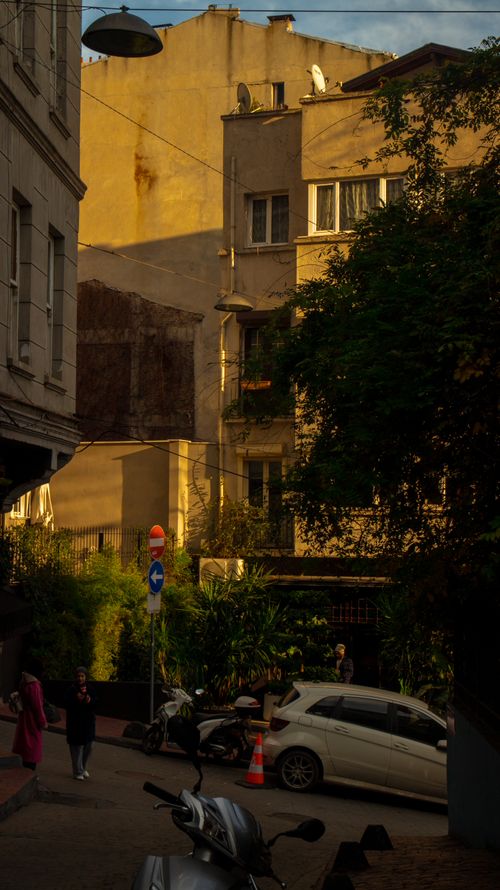 Free Charming European street with motorbikes and evening light casting shadows on old buildings. Stock Photo