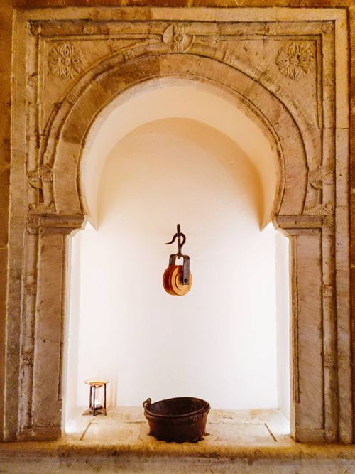 Free Stone arch niche with pulley system and bucket, historic architecture theme. Stock Photo