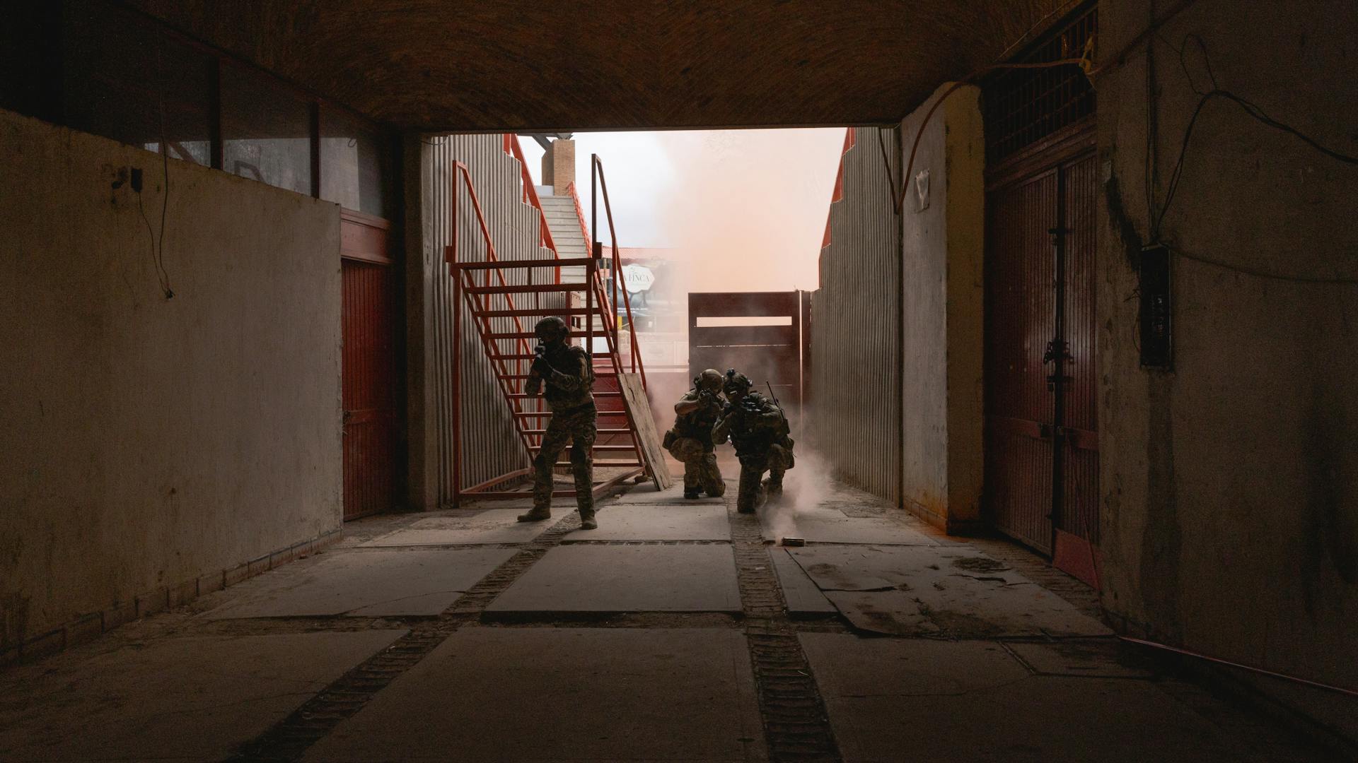 Soldiers conducting a tactical exercise in an industrial corridor.