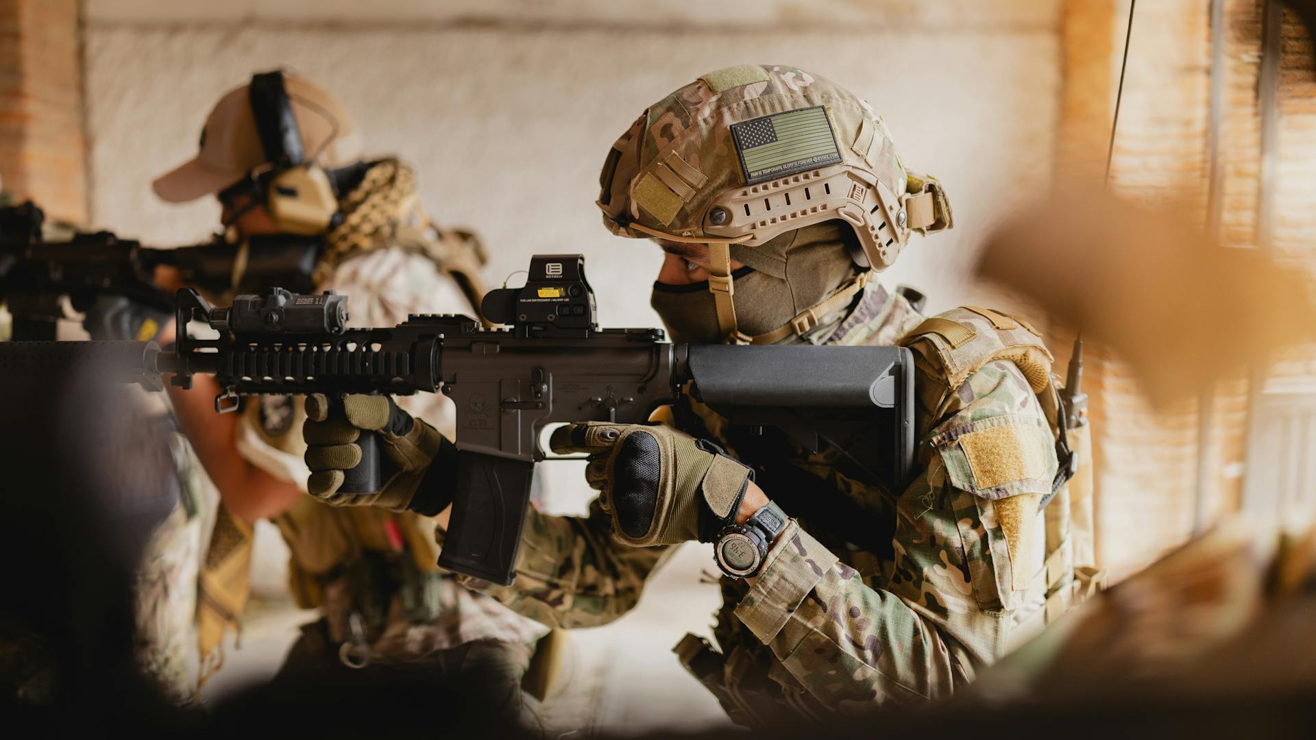 Soldiers engage in tactical training with firearms and combat gear indoors.