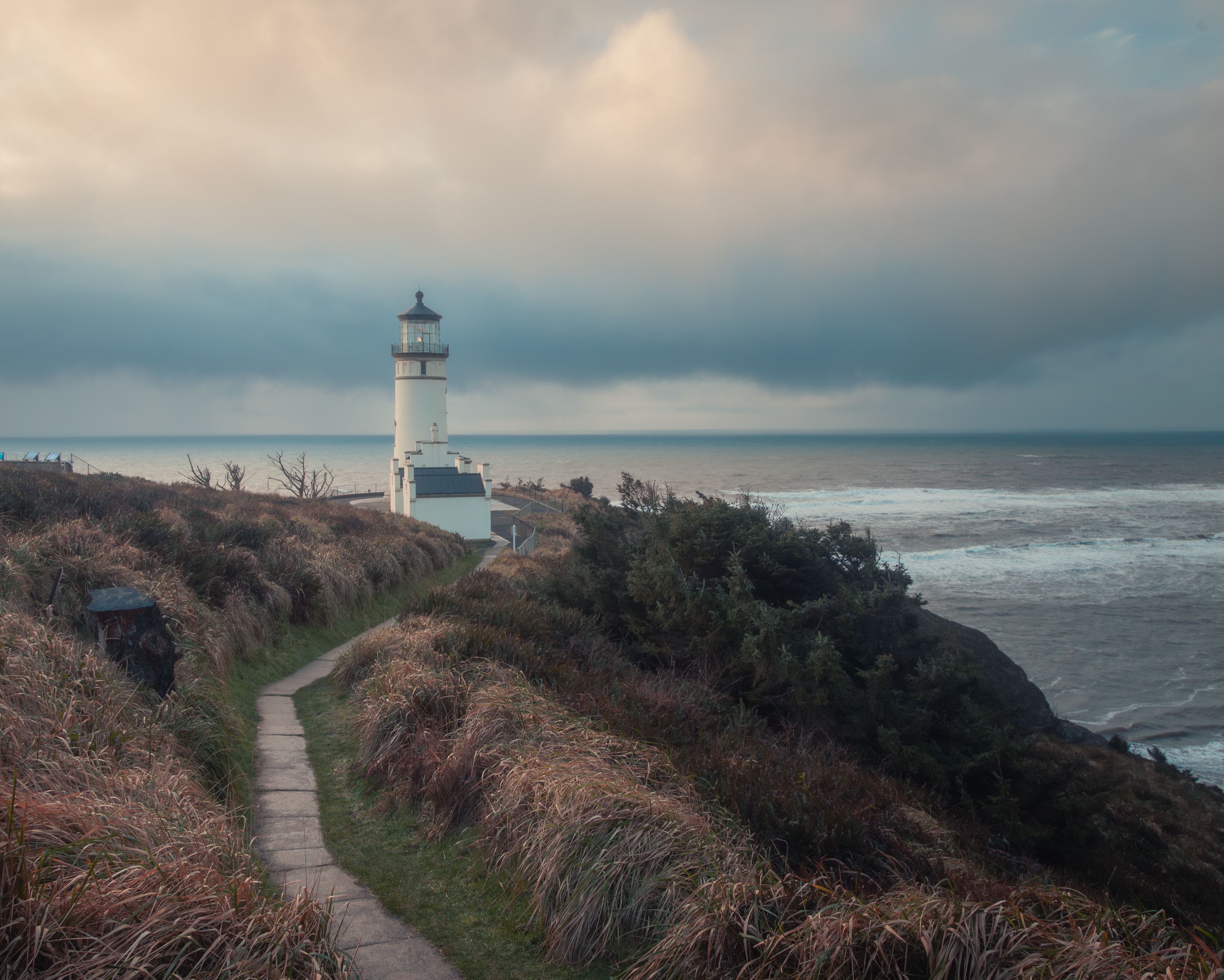 Scenic Lighthouse by Rough Coastal Shores at Dusk · Free Stock Photo