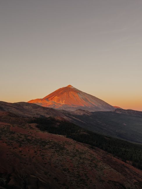 Dramatic sunset over Mount Teide, Tenerife's iconic volcanic peak, casting warm hues.